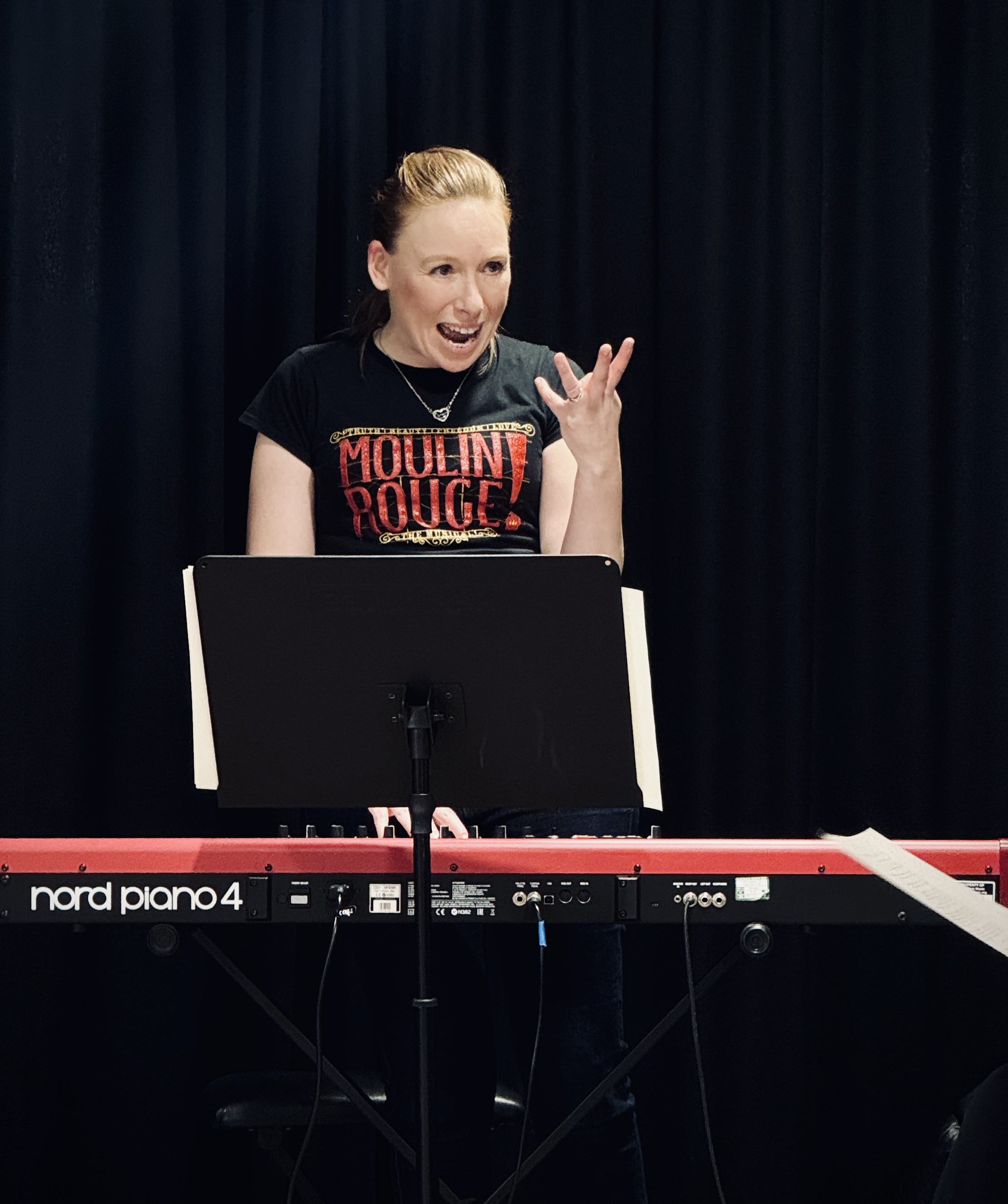 Gemma leading a Moulin Rouge workshop from the piano